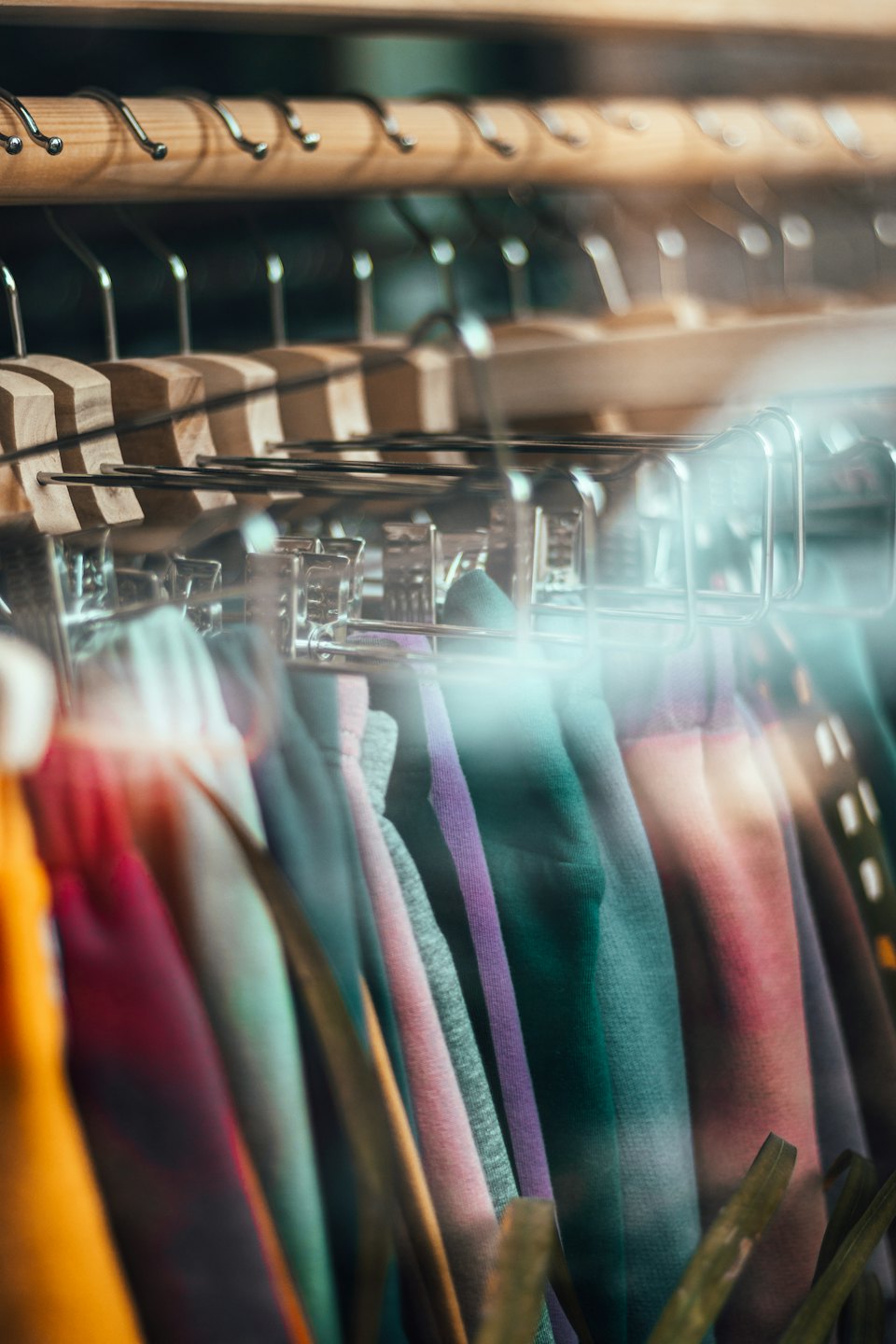 Colorful trousers hanging neatly on a retail clothing rack.