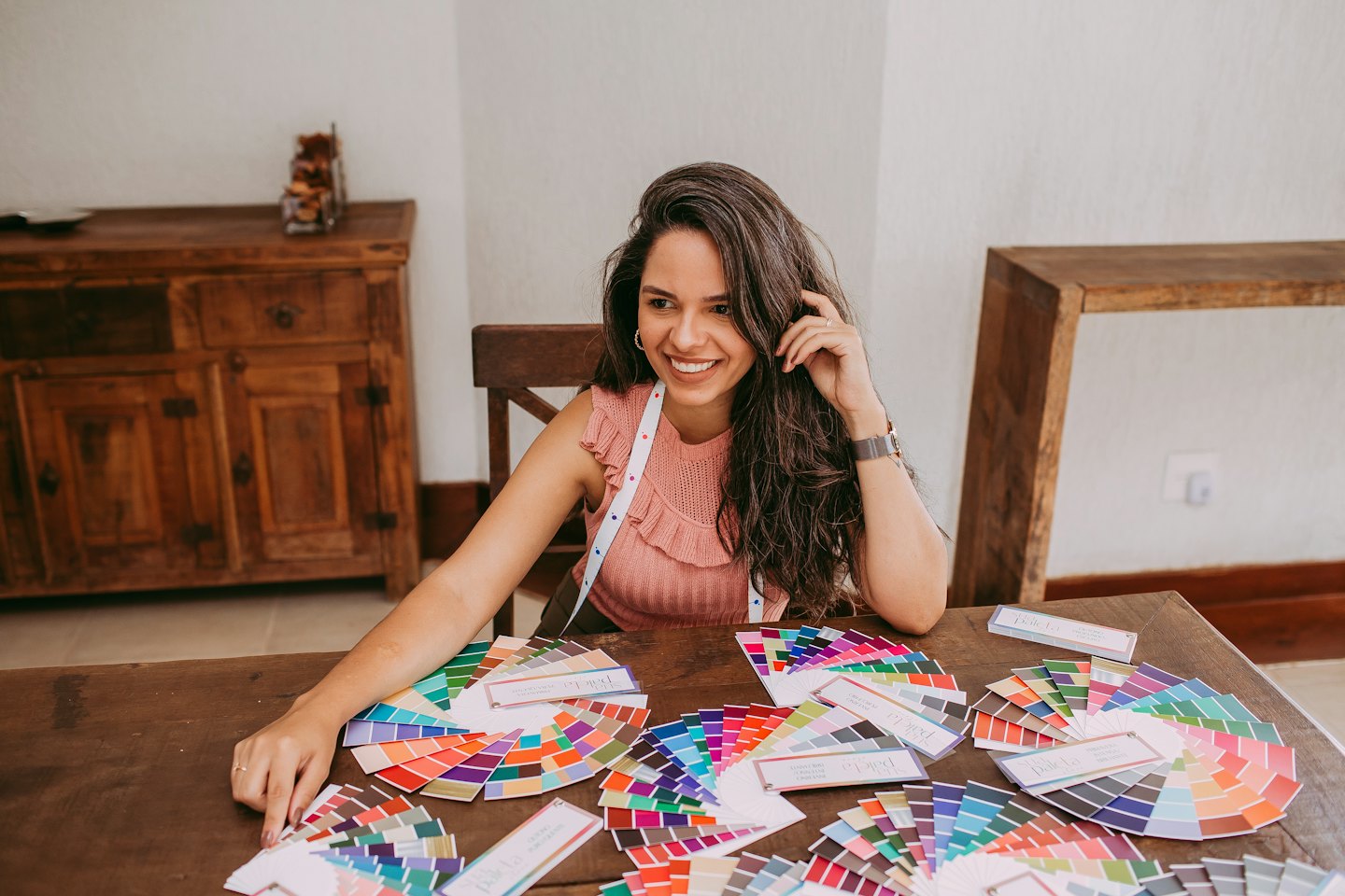 Designer working with color swatches on a wooden table.